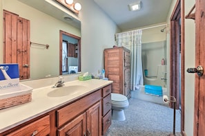 A bathroom with a wooden vanity, a large mirror, a sink, and a toilet. - Primitive Goshen Pine Lodge With Fireplace! (Middlebury)