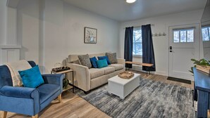 Un salon avec un canapé beige, un fauteuil bleu et une table basse blanche.