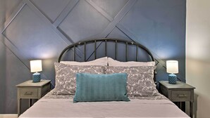 Une chambre à coucher avec un lit, deux tables de chevet et deux lampes.