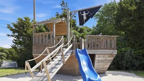 Eine Holzspielanlage mit Rutsche und Treppe.