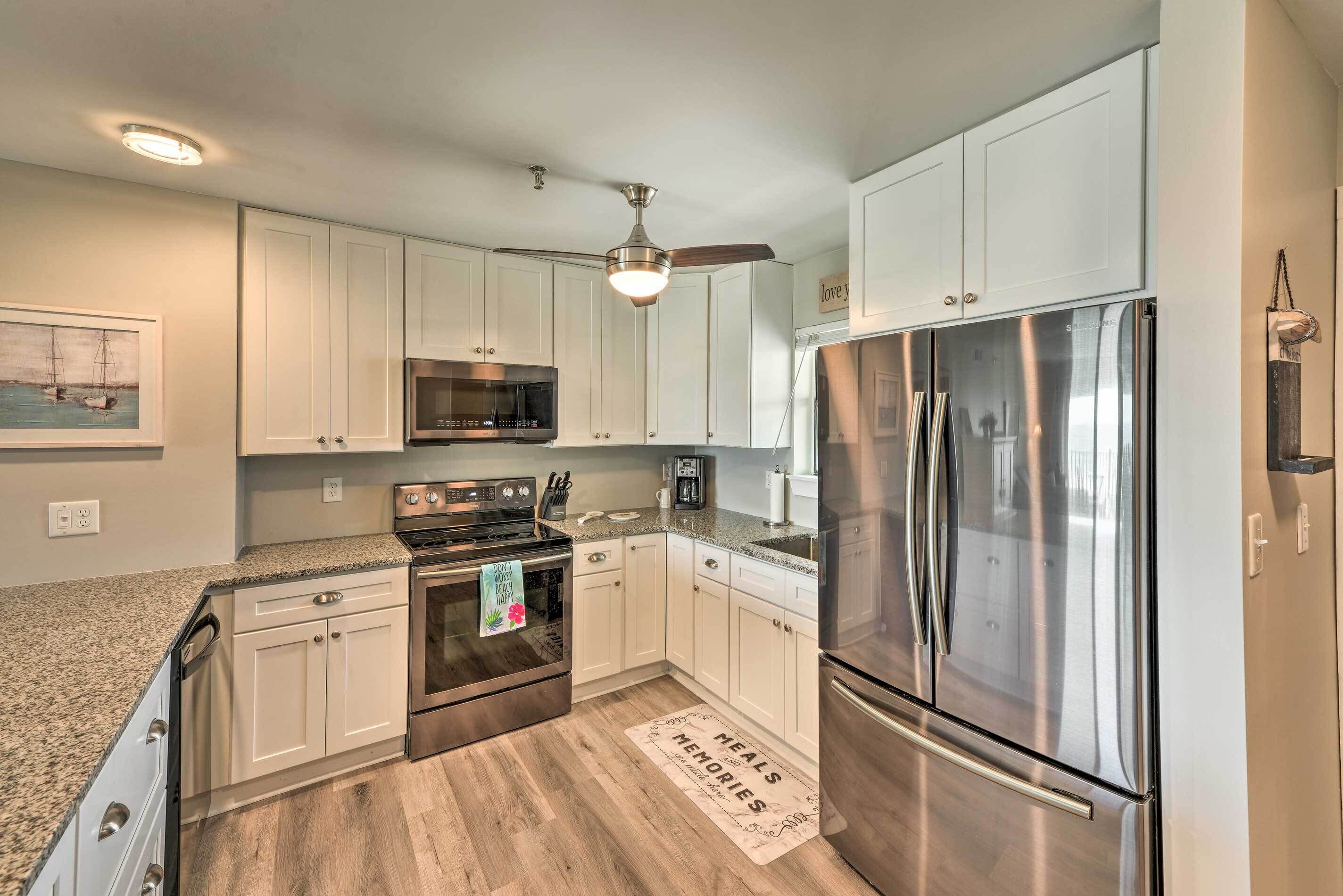 A modern kitchen with white cabinets, stainless steel appliances, and a granite countertop.