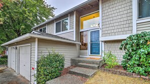 A two-story house with a garage, a front porch, and a well-maintained lawn. - Spacious Kent Getaway w/ Yard, Deck + Grill! (Kent)