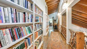 A library with bookshelves on both sides of a central walkway. - Chic Highlands Cabin Retreat w/ Deck + Office! (Highlands)