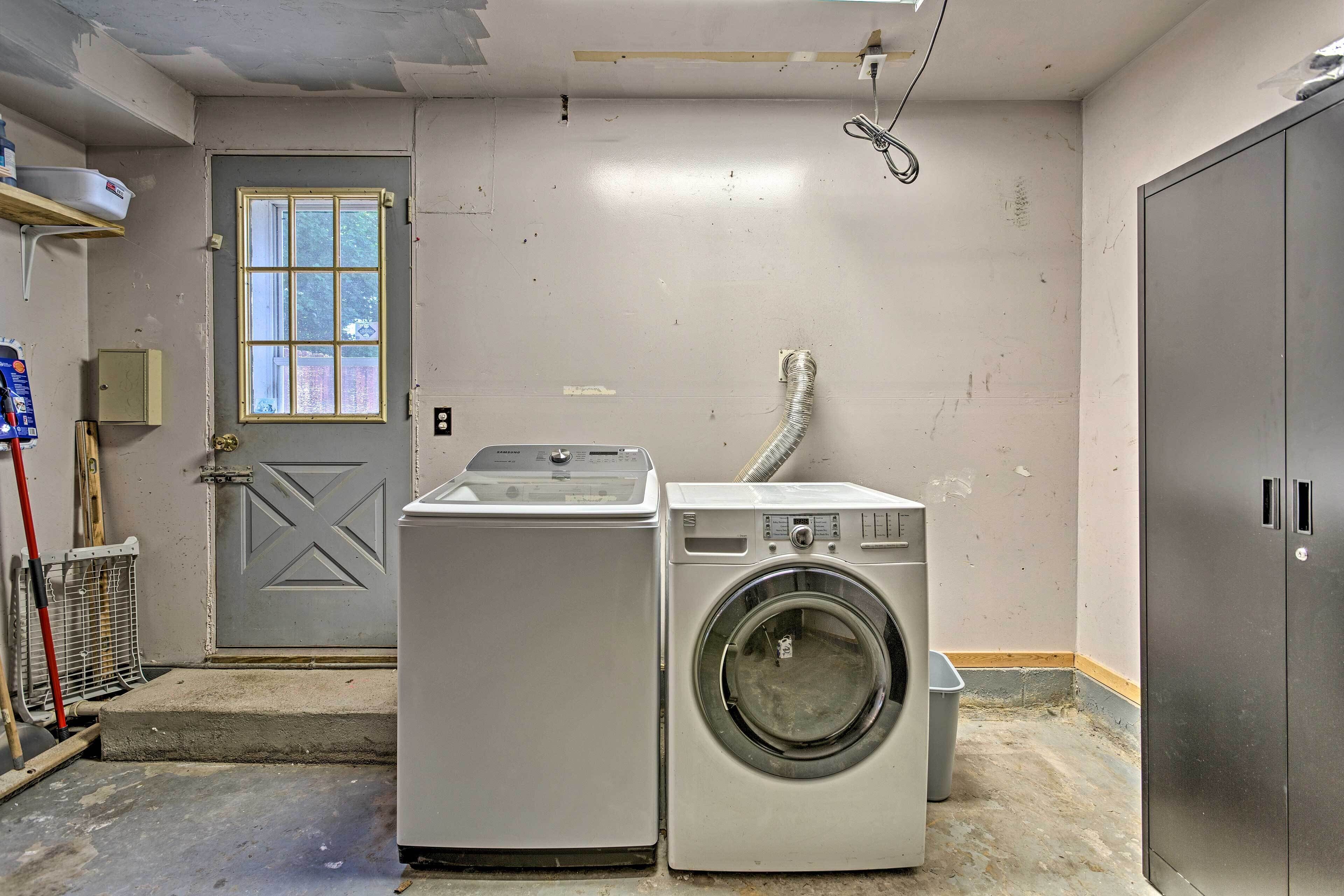 A laundry room with two washing machines, a door, and a utility room.