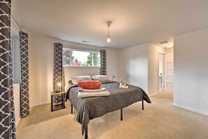 A bedroom with a bed, a nightstand, a window, and a door. - Sleek Cottage By Seattle's Top Sights, Lumen Field (Seattle)