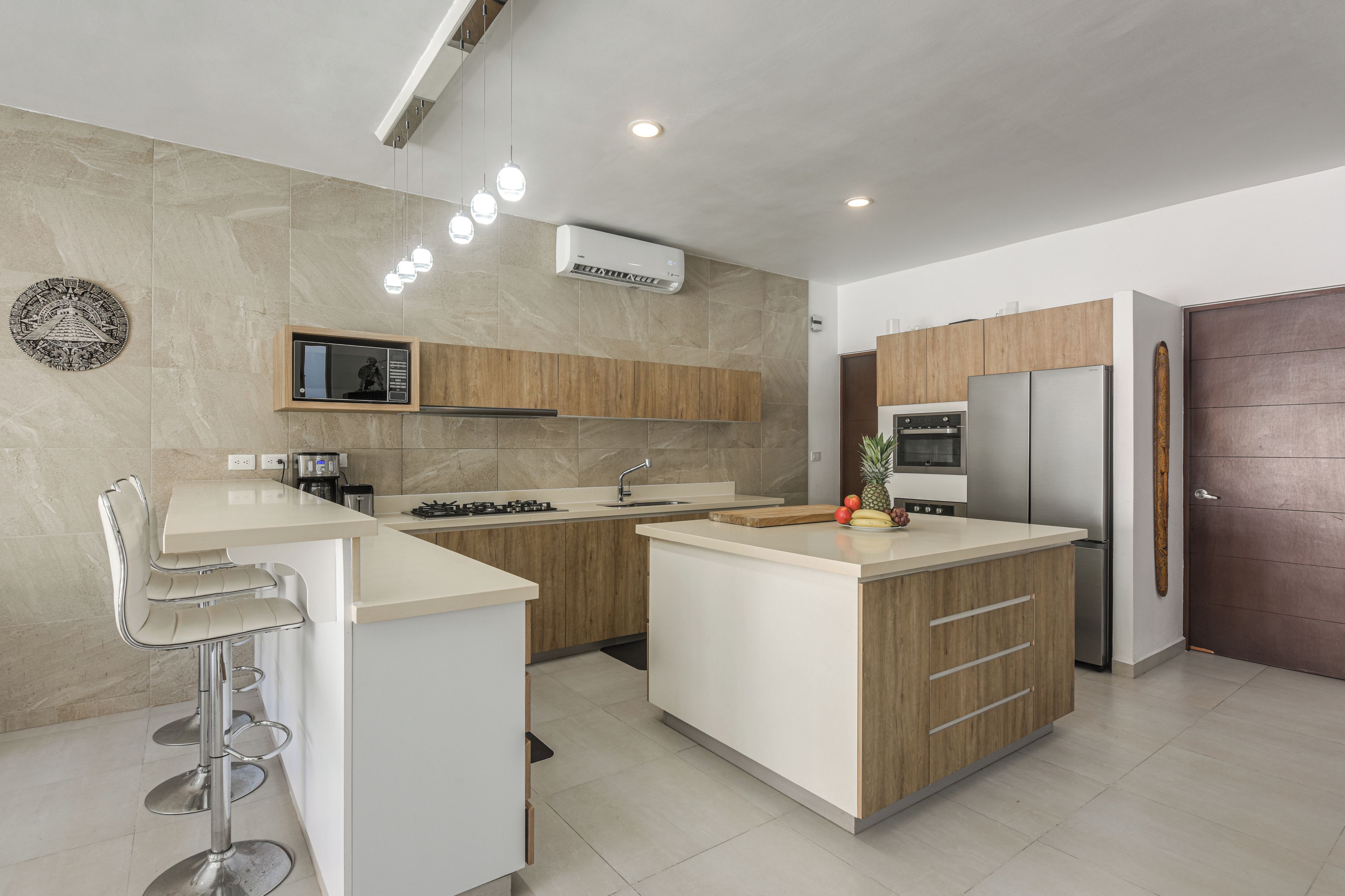 Una cucina moderna con isola centrale, elettrodomestici integrati e angolo bar.