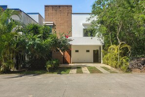 A modern two-story house with a brick chimney, a small front porch, and a concrete driveway. - 1 Mi to Beach: Luxe Playa Del Carmen Home w/ Pool (Playa del Carmen)