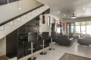 A modern interior with a staircase, bar stools, a sofa, and artwork on the walls. - 1 Mi to Beach: Luxe Playa Del Carmen Home w/ Pool (Playa del Carmen)
