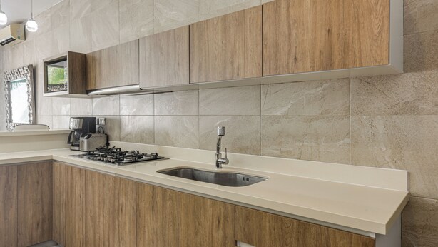Una cocina moderna con armarios de madera, un lavamanos de acero inoxidable y una estufa a gas.