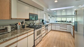 A modern kitchen with granite countertops, stainless steel appliances, and wooden cabinetry. - Spacious Family Home on Golf Course: Hike & Bike! (Bremerton)