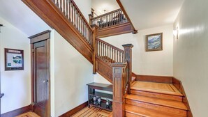 A wooden staircase with a handrail, a door, and a wall-mounted picture. - Historic Auburn House on 37 Acres w/ Private Lake! (Kent)