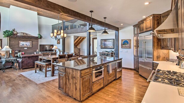 A spacious kitchen with a large island, stainless steel appliances, and wooden cabinetry. - Spacious Big Sky Cabin w/ Hot Tub & Grill! (Big Sky)