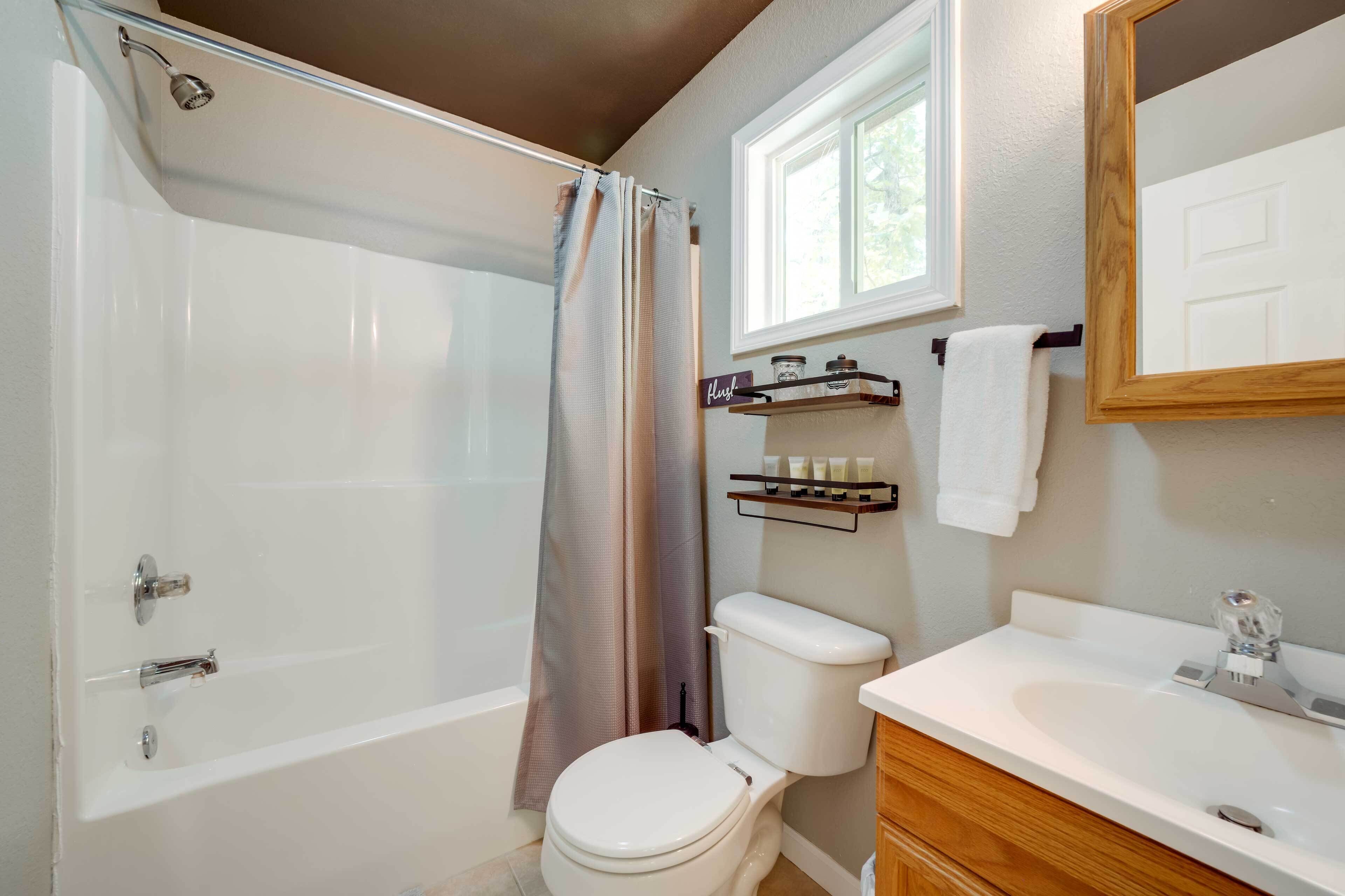 A bathroom with a bathtub, toilet, and sink.