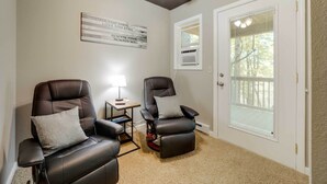 A room with two leather recliners, a ceiling fan, a small table with a lamp, and a window with blinds. - Private Hot Tub, Yard: Pet-friendly Whittier Cabin (Whittier)