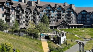 Ein mehrstöckiges Hotel mit Steinaußengebäude, Balkonen und einem Poolbereich.