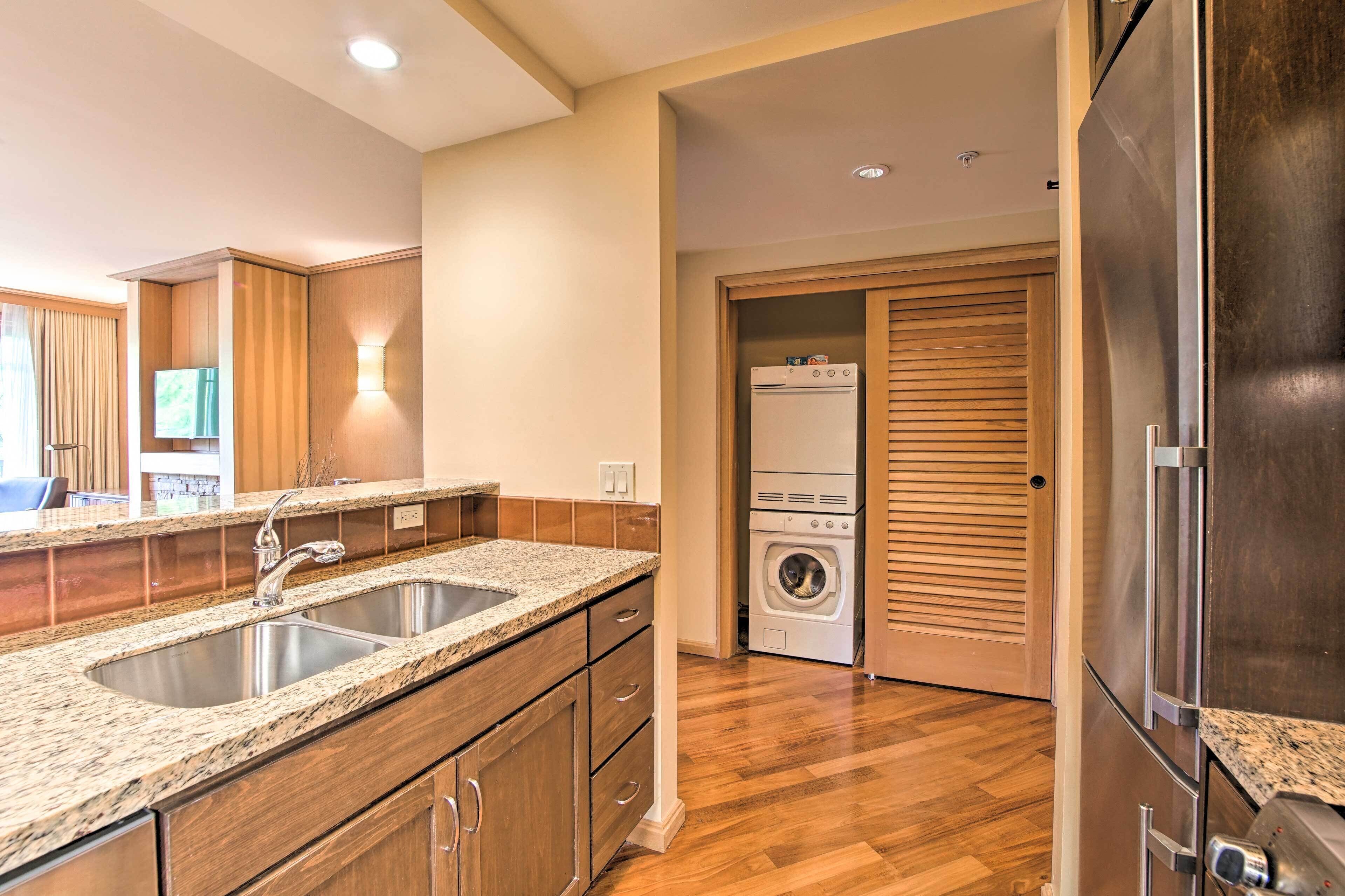 A modern kitchen with granite countertops, stainless steel appliances, and wooden cabinetry.