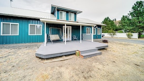 A two-story house with a covered porch and a small deck.