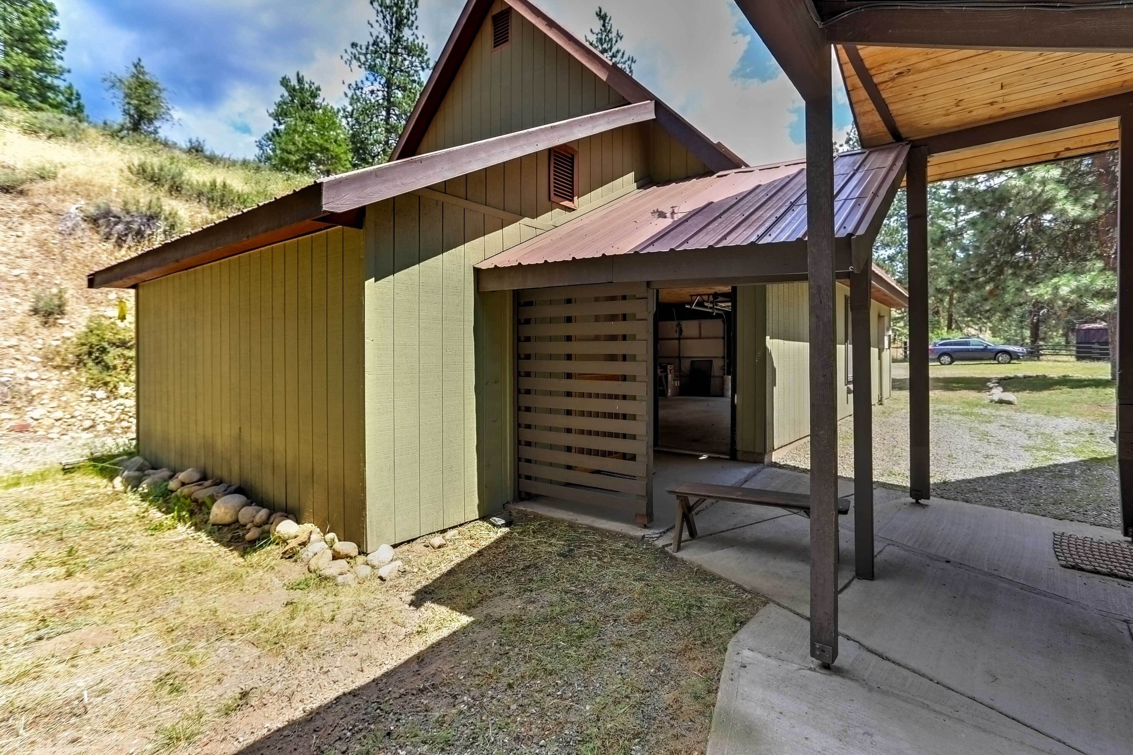 A wooden cabin with a covered porch, a small entryway, and a gravel path leading to the door.