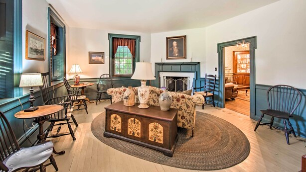 A traditional living room with a fireplace, a sofa, a coffee table, and a dining table with chairs. - Beautiful Historic House In Amish Country (Ephrata)