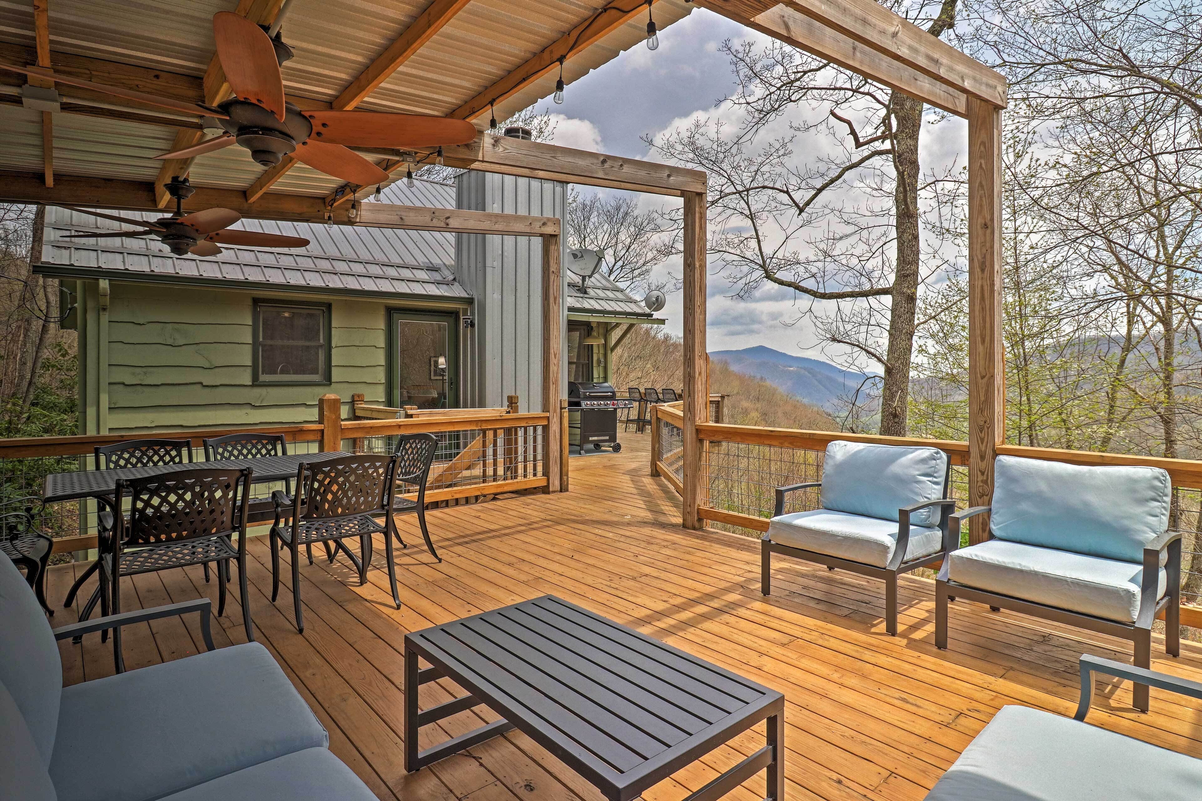 A wooden deck with outdoor furniture, a pergola, and a view of mountains.