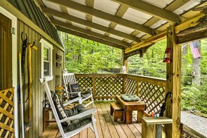 A wooden deck with outdoor furniture, a wooden railing, and a view of a forest. - 'lotsa Moose Lodge' Pisgah Forest Waterfall Cabin! (Burnsville)