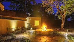 A stone patio with a fire pit, surrounded by a wooden fence and a tree. - 18 Mi to Dtwn Memphis: Oasis on 8 Acres! (Southaven)