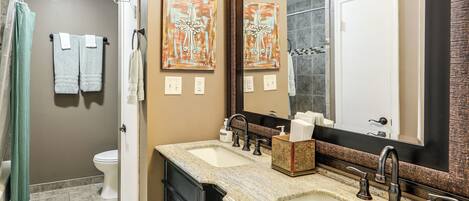 A bathroom with a sink, mirror, towel rack, and toilet.
