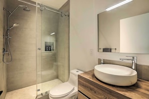 A modern bathroom with a glass-enclosed shower, a white toilet, and a wooden vanity with a large sink. - Sleek & Spacious Incline Village Hideaway! (Incline Village)