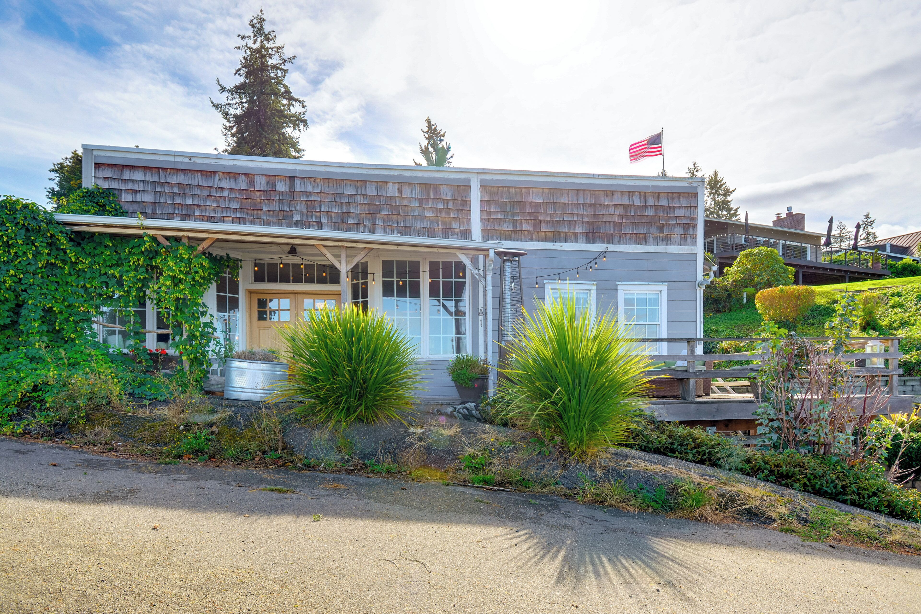 A two-story building with a covered porch and a flag on top.