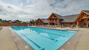 Ein Pool mit Liegestühlen und ein Holzbalkon.