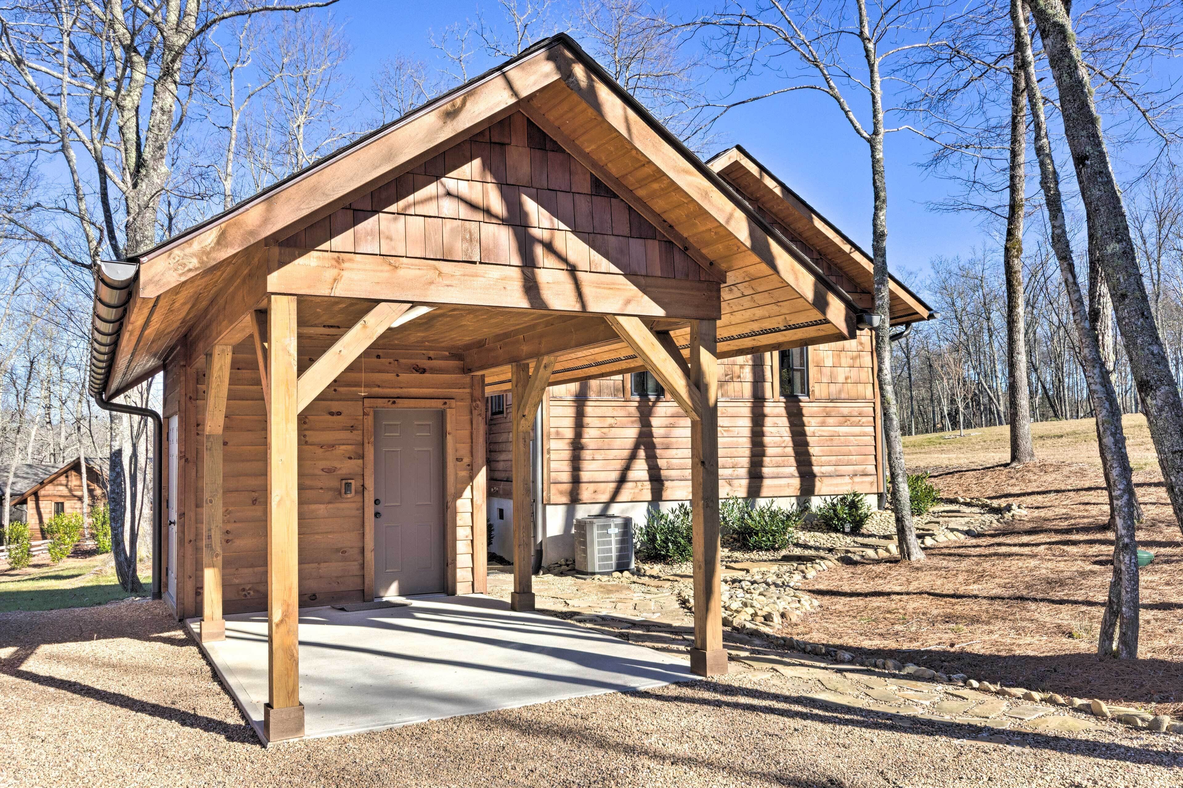 A wooden cabin with a porch, a door, and a window.