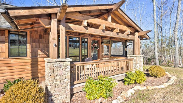 A wooden cabin with a stone foundation, a covered porch, and a landscaped garden. - Pet-friendly Cabin w/ Mtn Views in Chinquapin! (Glenville)