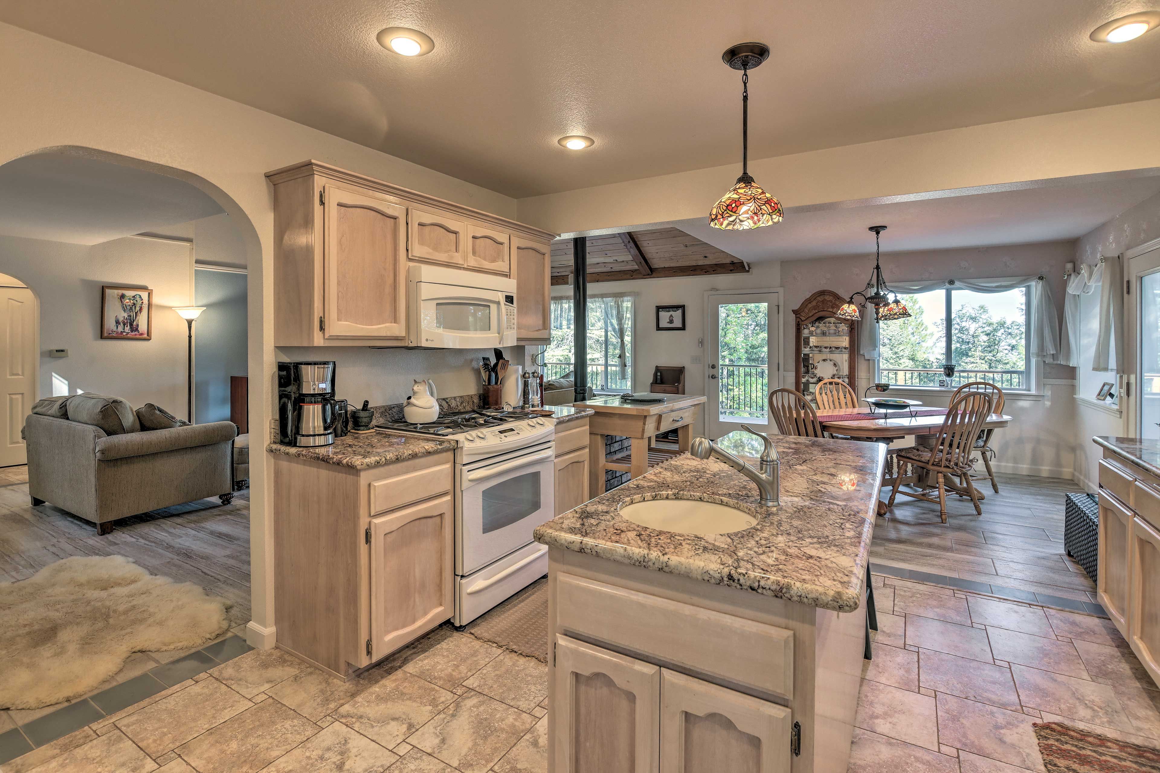 A spacious kitchen with a central island, wooden cabinets, and a dining area with a table and chairs.