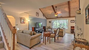 A spacious living room with a high ceiling, wooden beams, a television, a fireplace, and a dining area with a table and chairs. - 20 Mi to Lassen Park: Chateau w/ Mt Shasta View! (Shingletown)
