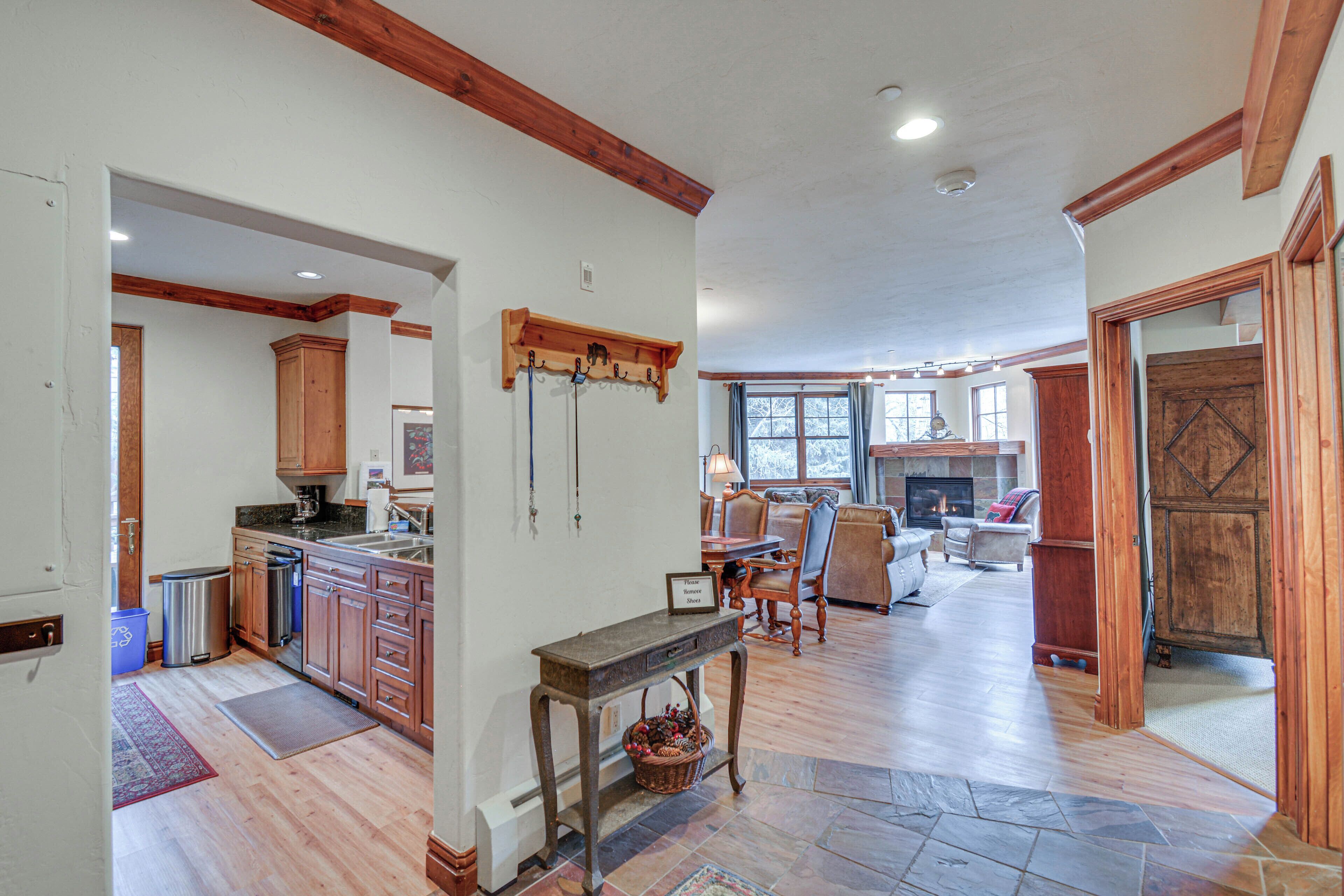 A spacious living area with a fireplace, wooden flooring, and a dining area.