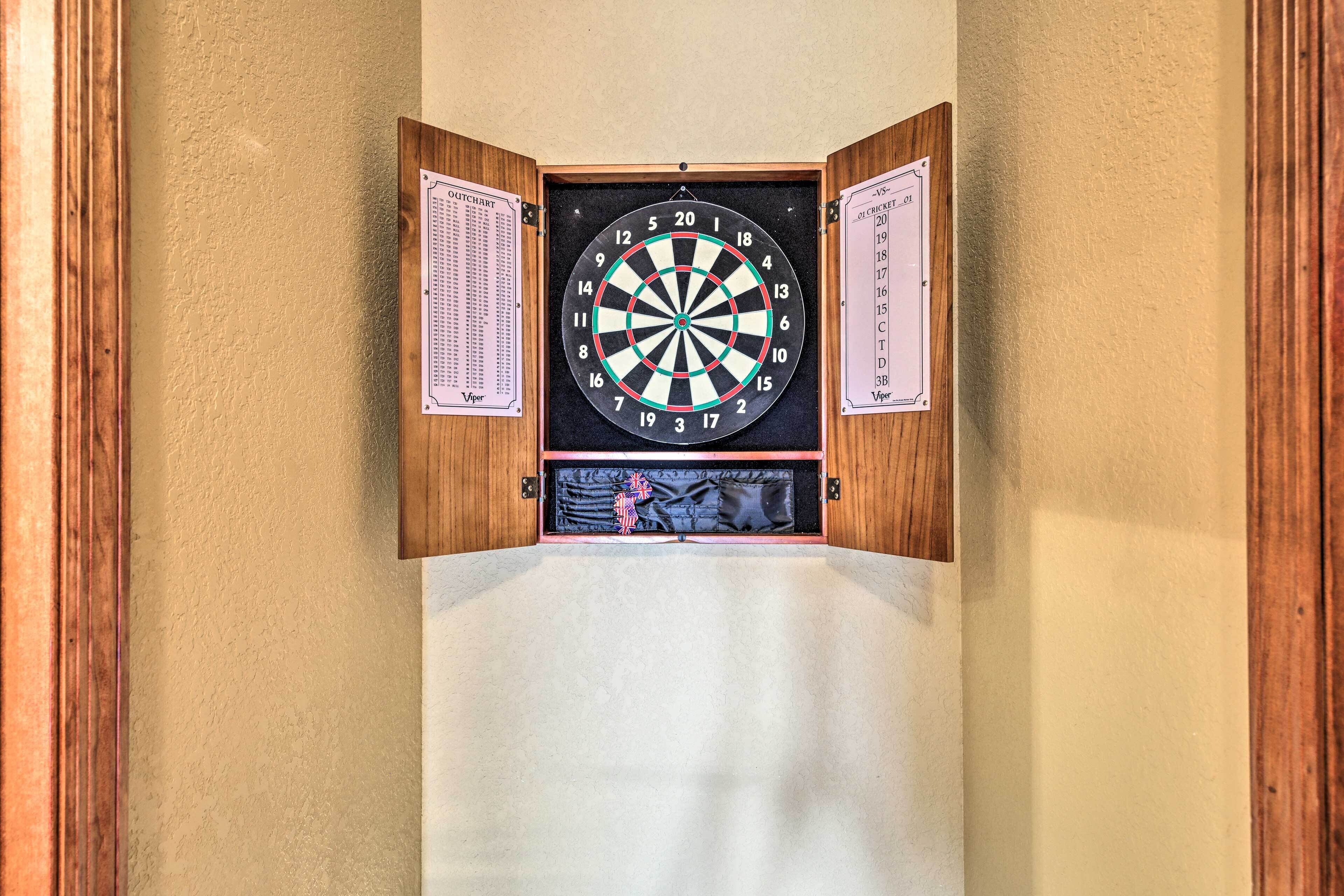 Tablero de dardos colgado en una pared, con un diagrama del tablero y un reglamento a la vista.