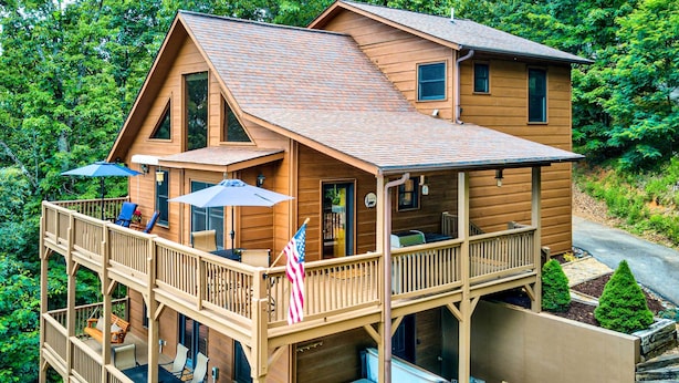 Une cabane en bois à deux étages, dotée d’une terrasse, d’un bain à remous et d’un espace salon extérieur.