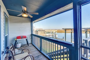 A covered porch with a ceiling fan, a red gas canister, and a metal lantern.