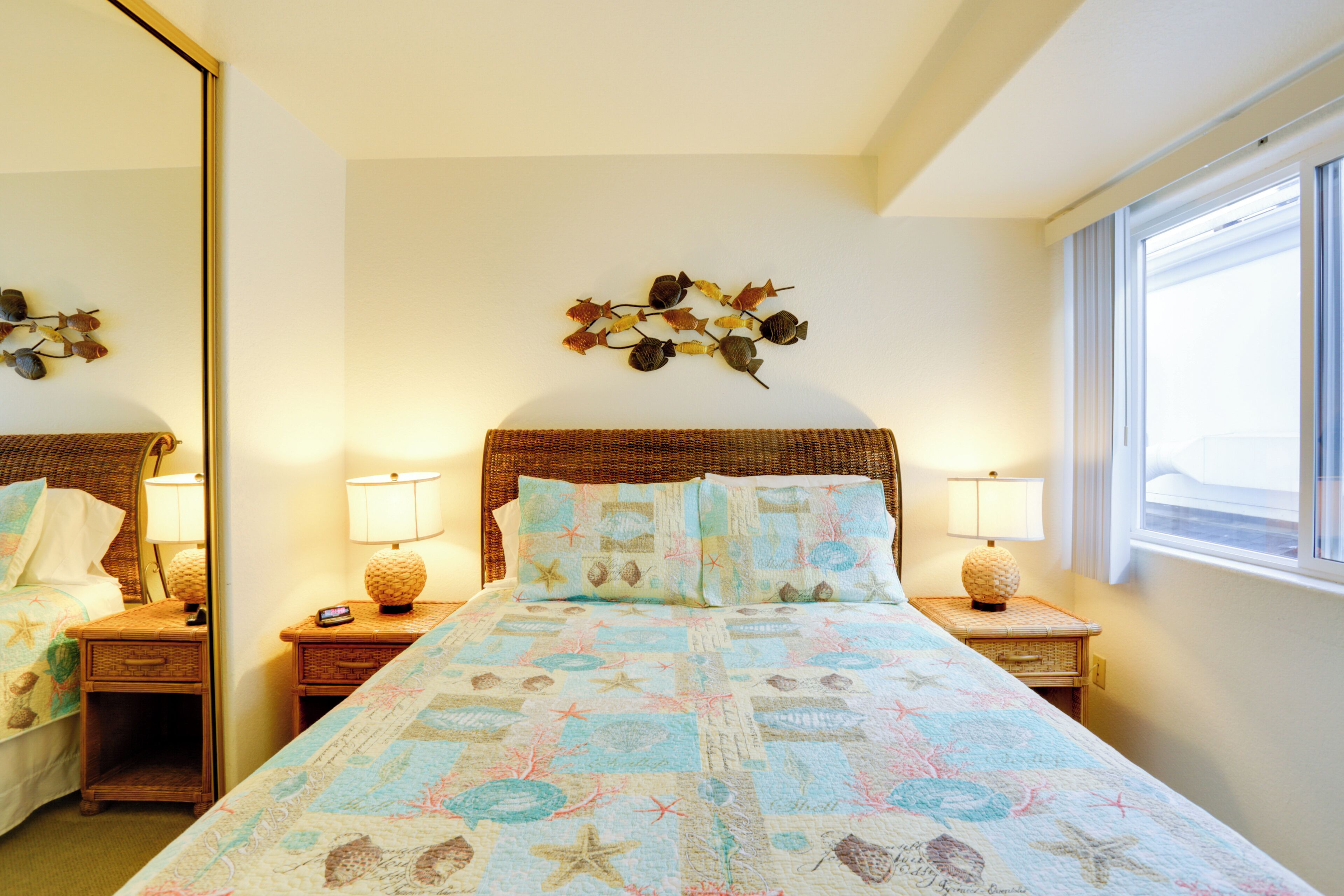 Une chambre à coucher avec un grand lit, deux tables de chevet, un miroir et un élément décoratif mural.