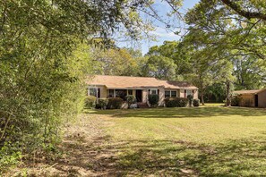 A single-story house with a front porch, surrounded by a well-maintained lawn and dense trees. - Spacious Retreat, 2 Mi to Tuskegee University (Tuskegee)