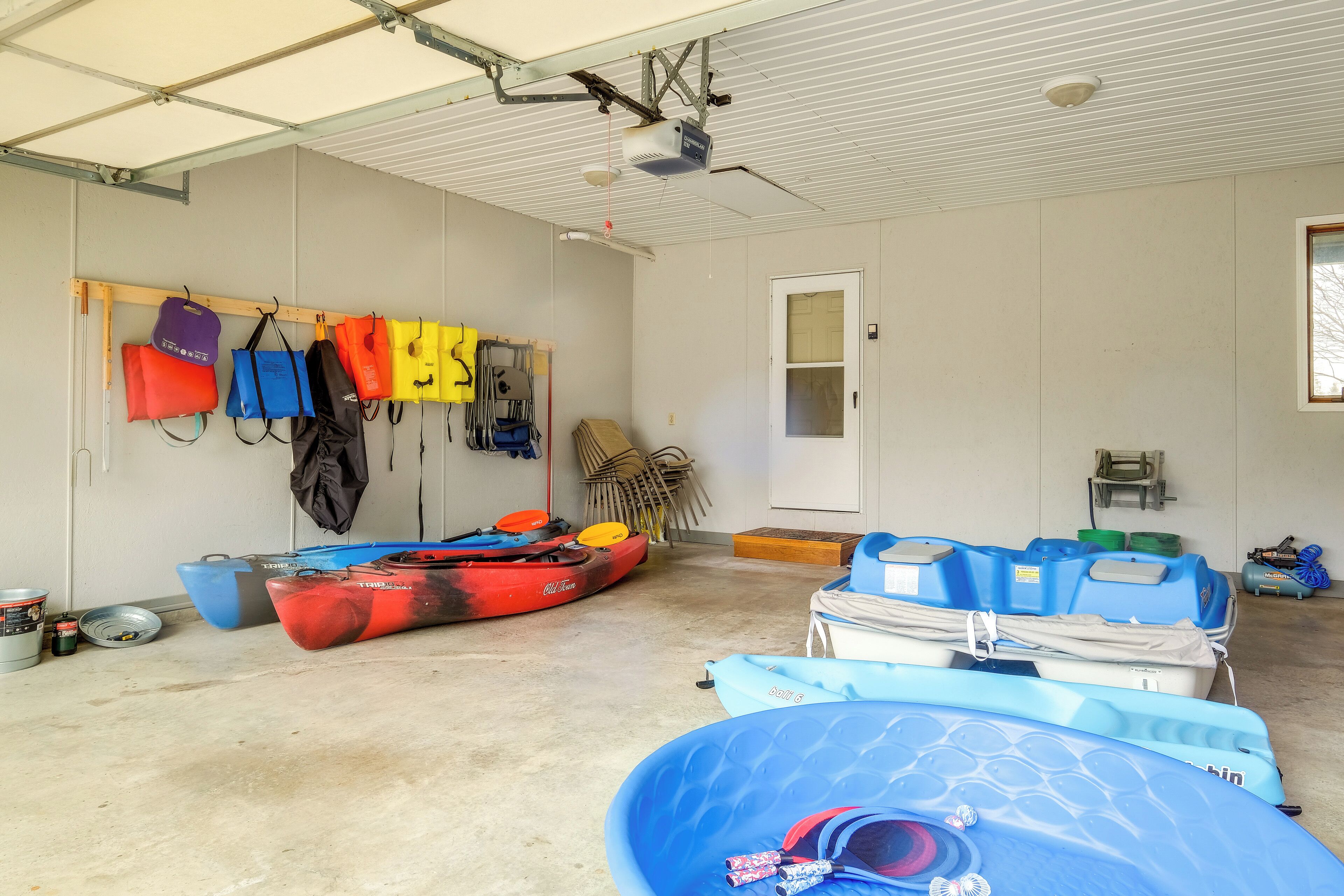 A garage with kayaks and life jackets.