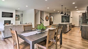A modern kitchen with wooden cabinets, a central island, and pendant lighting. - Upscale Townhome in Causeways on Gull Resort! (Nisswa)