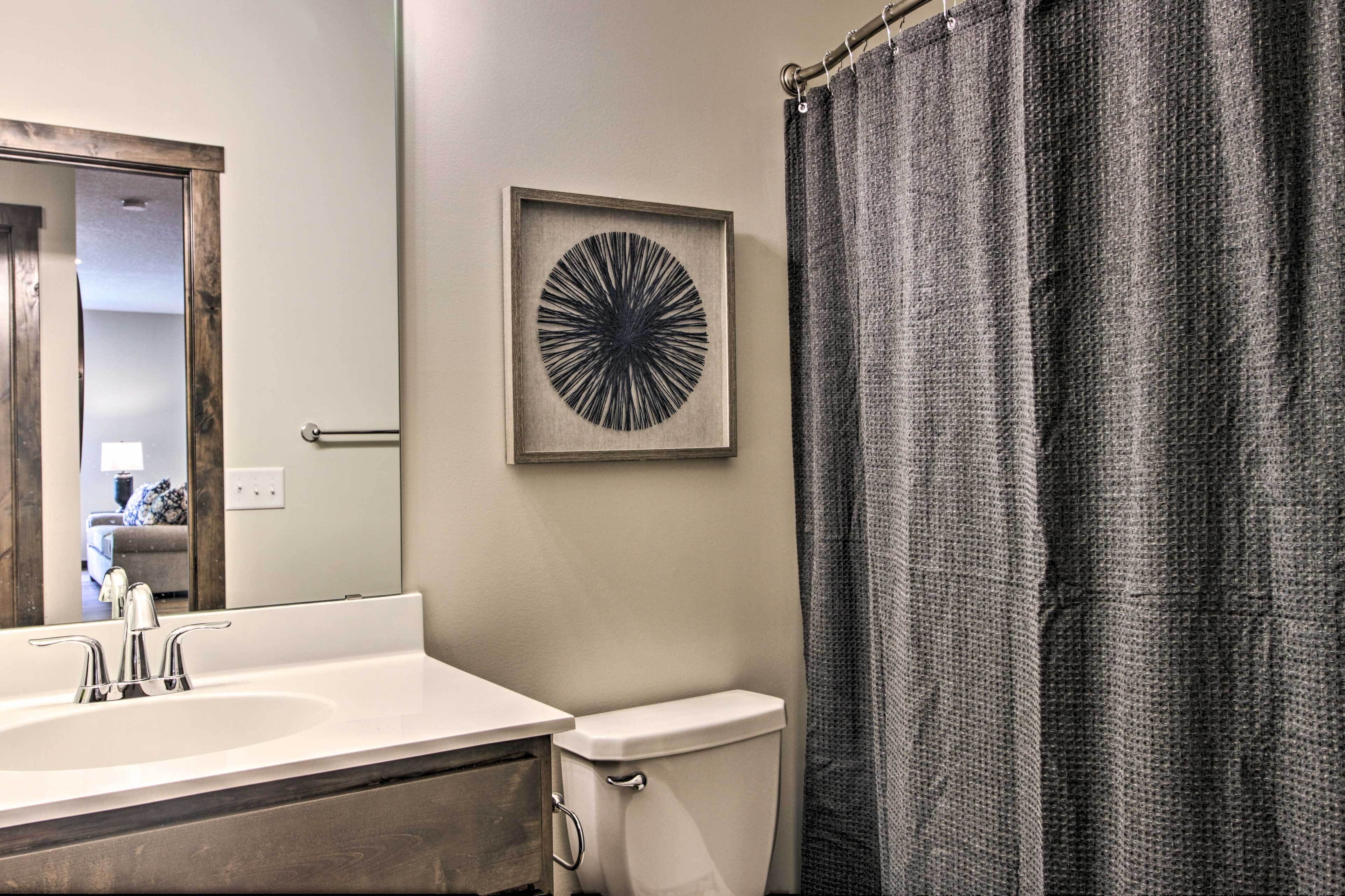A bathroom with a white sink, a toilet, and a shower curtain.