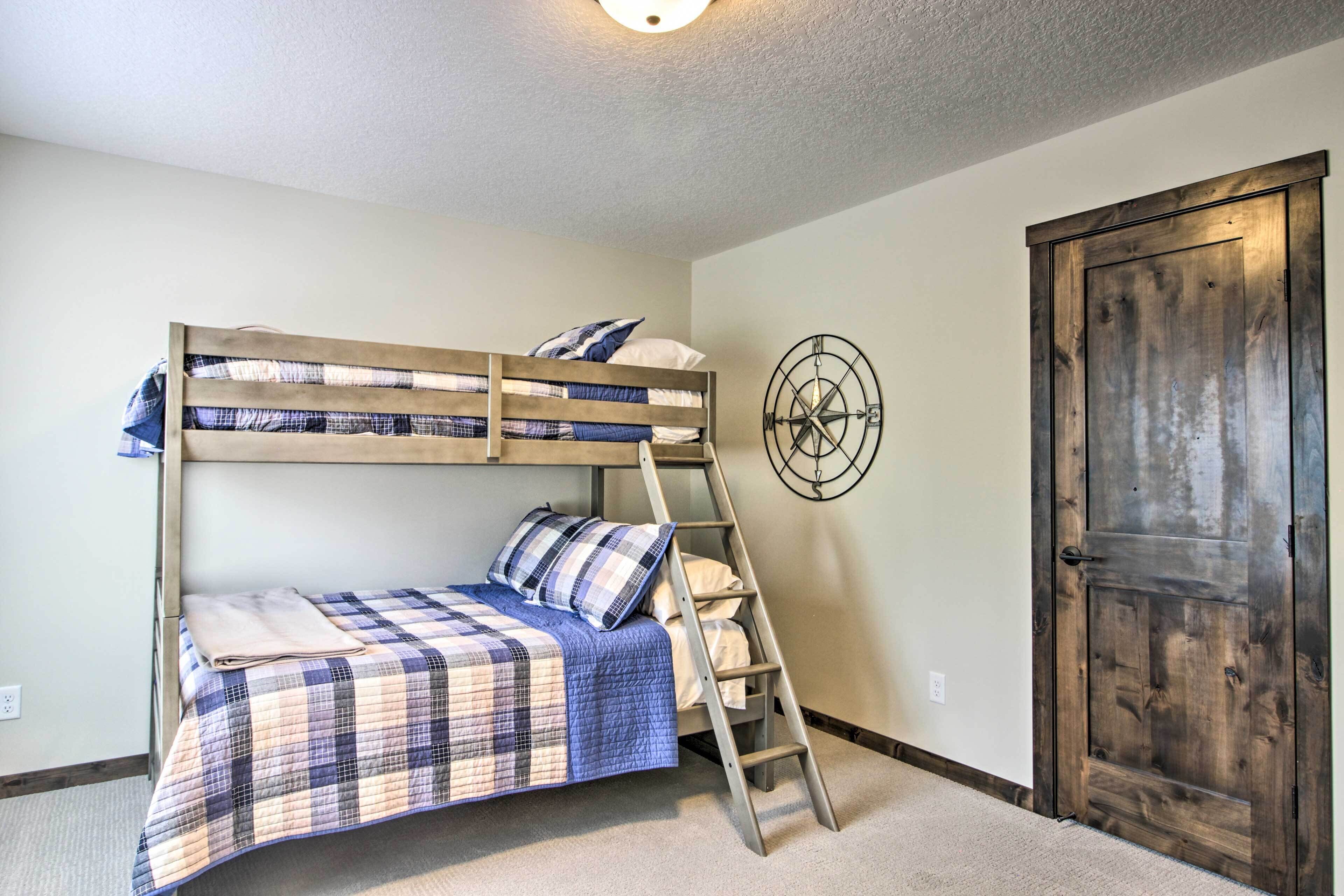 Una cama litera con escalera, una puerta de madera y un reloj fijado a la pared.