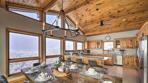 A spacious kitchen with wooden cabinets, a stainless steel refrigerator, and a large island with a sink. - Views & Hot Tub! Beech Mtn 'sky Barn Retreat' (Banner Elk)