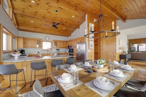 A spacious kitchen with wooden cabinets, a large island, and modern appliances. - Views & Hot Tub! Beech Mtn 'sky Barn Retreat' (Banner Elk)