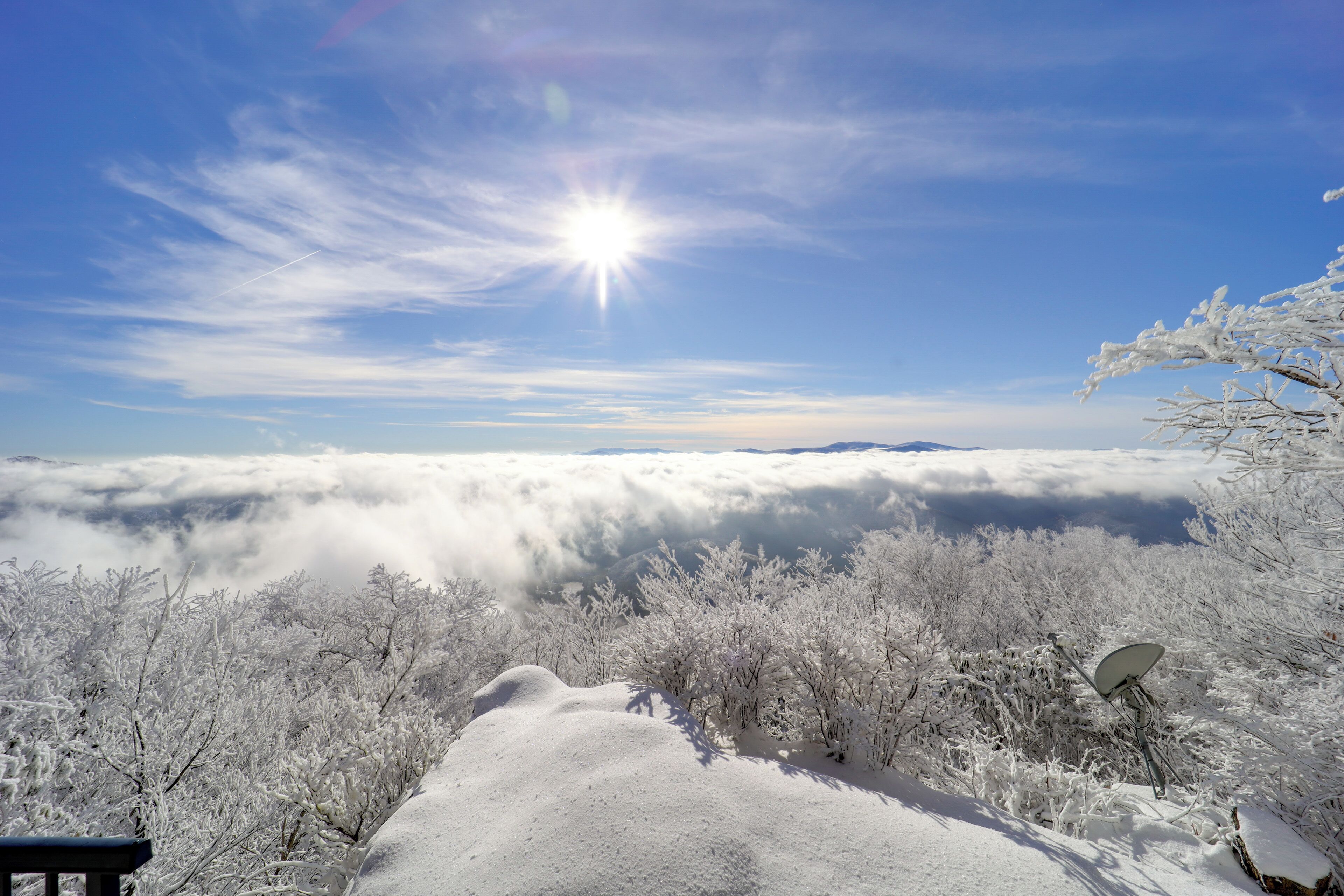 A snowy landscape with a clear sky and a satellite dish.