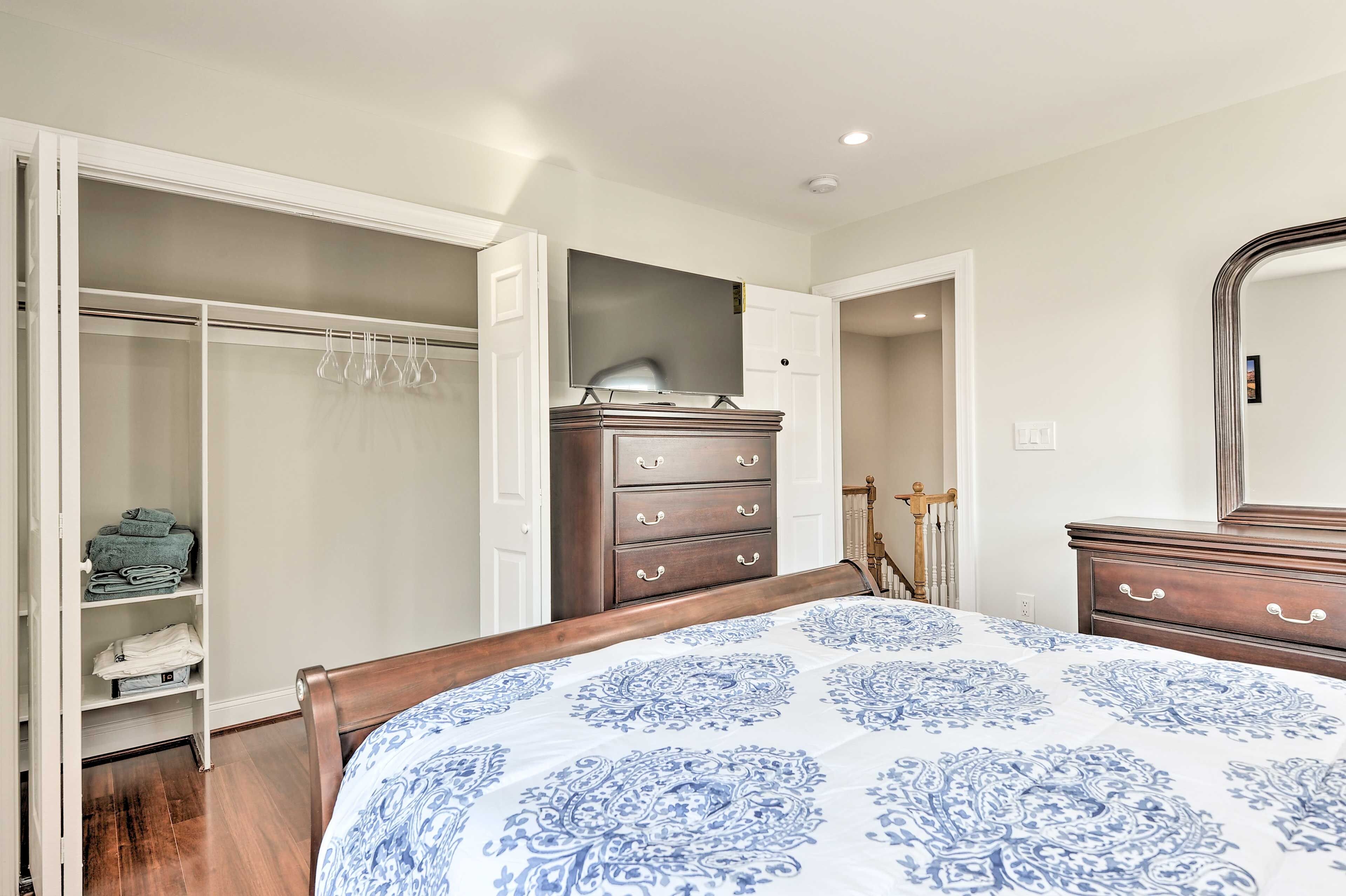 A bedroom with a bed, a wardrobe, a dresser, and a mirror.