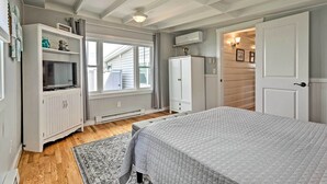 A bedroom with a bed, a TV, a wardrobe, and a window. - Waterfront Portsmouth Cottage: 8 Mi. From Newport! (Portsmouth)