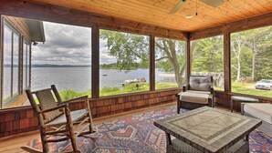 A covered outdoor area with a view of a lake, wooden flooring, and seating arrangements. - Waterfront Star Lake Cabin, Boat Dock On-site (Star Lake)